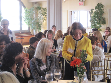 Liana Monie (standing right) as she opens the N.A.W.A. medal for lifetime achievement at the National Association of Women Artists' annual Meeting and Luncheon