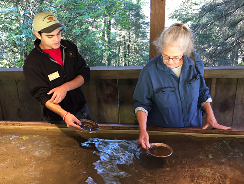 Cornelia Seckel being instructed on the art of  panning for gold