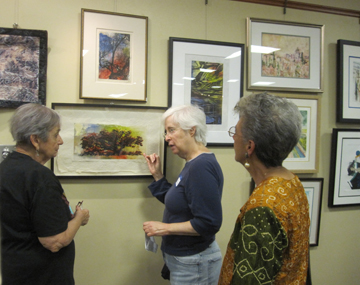 Barbara Flamm and Liz Ehrlichman discussing the work at the Printmaking Exhibit in Manhassett as another printmaker looks on