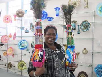 teresa warner in the dockyard glassworks hot shop and studio glass gallery exchanging some of her gombey dolls 